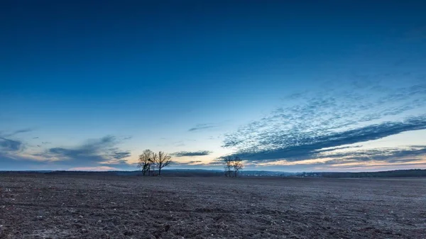 Bel cielo colorato tramonto sul campo arato in primavera — Foto Stock