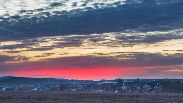 Pôr do sol céu colorido sobre aldeia polonesa na primavera — Fotografia de Stock