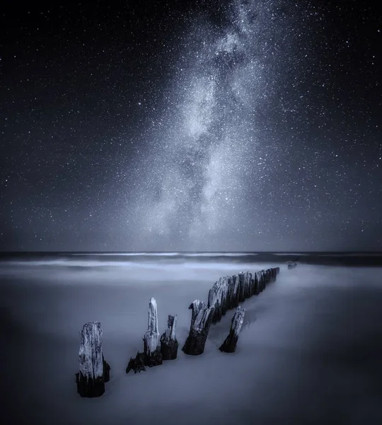 Havet Nattlandskap med Vintergatan över gamla träpiren — Stockfoto
