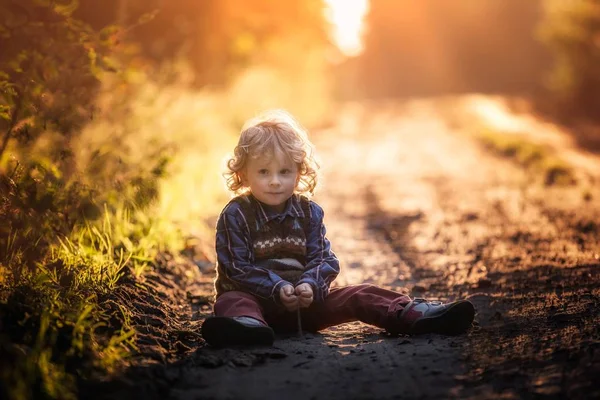 Маленький хлопчик грає на відкритому повітрі в автономному світлі — стокове фото