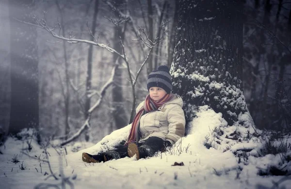 Щасливий молодий хлопчик грає в снігу — стокове фото