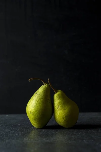 Green pears lying on dark background — Stock Photo, Image