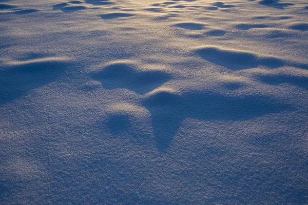 Belos padrões de neve iluminados com luz dourada do pôr do sol — Fotografia de Stock