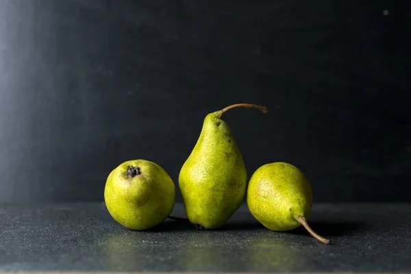 Green pears lying on dark background — Stock Photo, Image