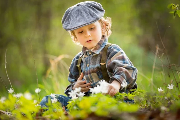 Menino pequeno brincando na floresta de primavera — Fotografia de Stock