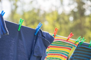 Çamaşır ipi ve açık havada kuru giysiler. Giysiler dışarıda çamaşır ipine asılı..