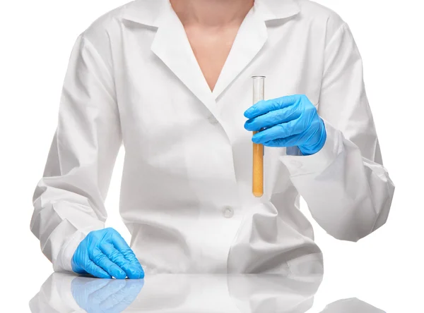 Female in gown and gloves holding test tube with sorbent — Stock Photo, Image