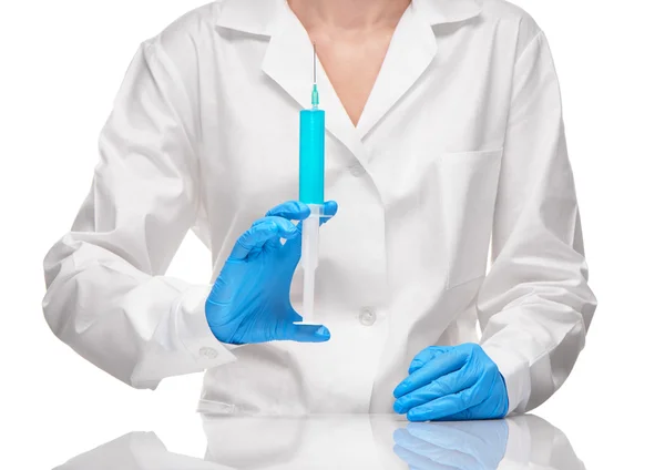 Doctor in gown and gloves holding syringe with blue drug — Stock Photo, Image