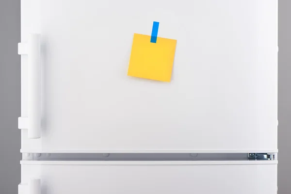 Nota de papel amarillo en blanco y pegatina azul en refrigerador blanco — Foto de Stock