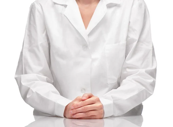 Female in white gown sitting at table against white background — Stock Photo, Image