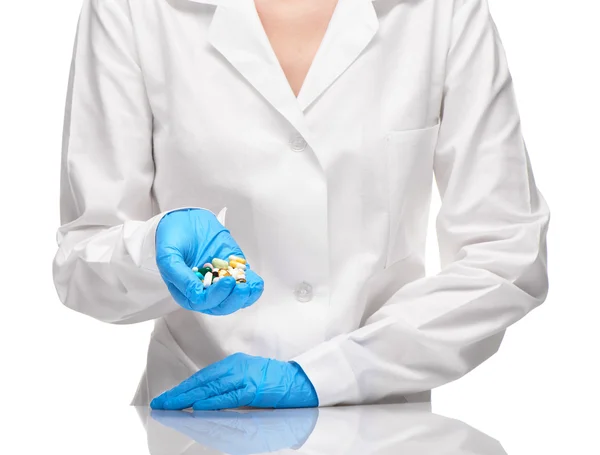 Doctor in white gown and gloves holding tablets and capsules — Stock Photo, Image