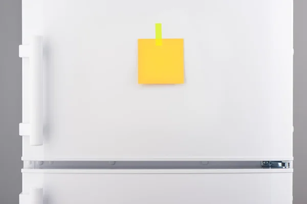 Nota de papel amarelo anexada com adesivo no refrigerador branco — Fotografia de Stock