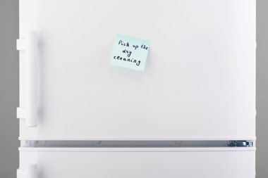 Kuru Temizleme beyaz buzdolabı üzerinde mavi notepaper üzerinde almak 