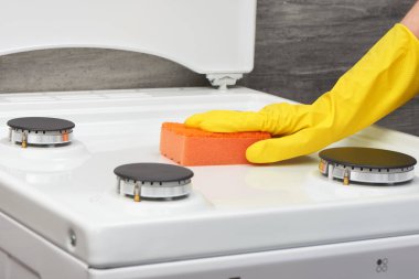 Sarı eldiven beyaz turuncu sünger ile soba temizlik el