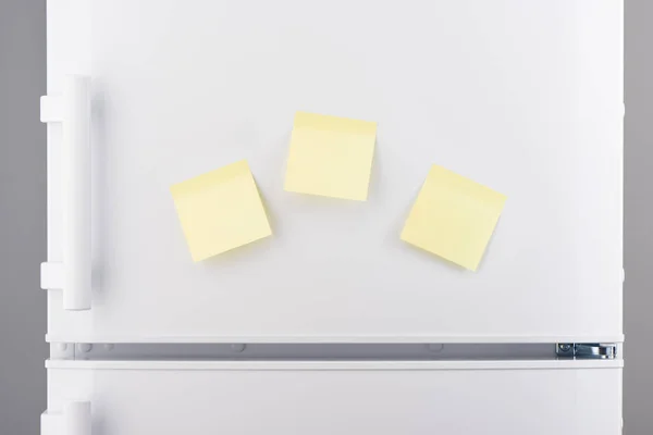 Notas de papel adhesivo amarillo claro en blanco sobre refrigerador blanco —  Fotos de Stock