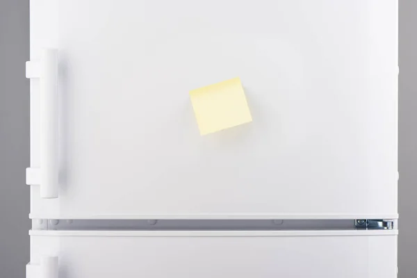 Blank light yellow sticky paper note on white refrigerator — Stock Photo, Image