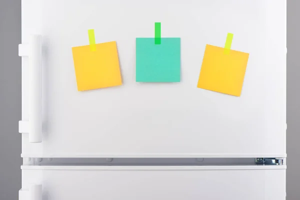 Notas de papel verde y amarillo en blanco pegadas al refrigerador — Foto de Stock