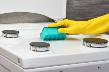 Sarı eldiven yeşil sünger ile soba beyaz temizlik el 