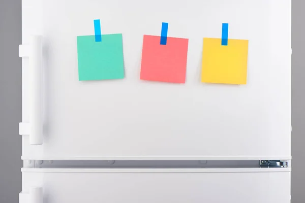 Green, pink, yellow notes attached with stickers on refrigerator — Stock Photo, Image