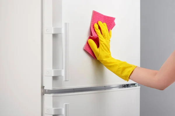 노란 장갑 핑크 걸 레로 흰색 냉장고를 청소에 — 스톡 사진