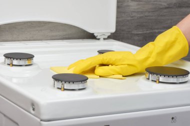 Sarı eldiven beyaz bez ile soba temizlik el