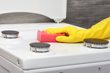 Pembe sünger ile soba beyaz temizlik sarı eldiven el