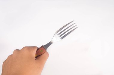 Paslanmaz çelik çatal beyaz arka plan üzerinde tutan el
