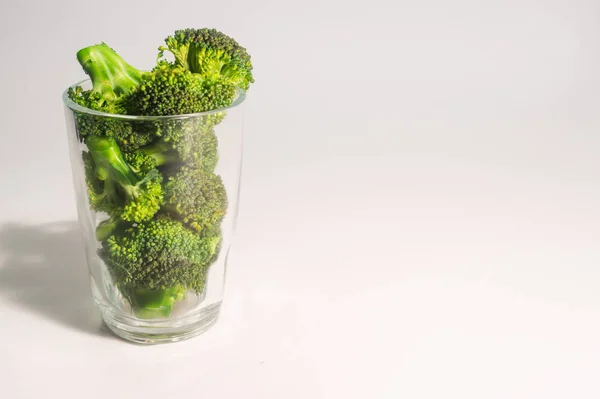 Grüne Brocolli in transparentem Glas auf weißem Hintergrund — Stockfoto