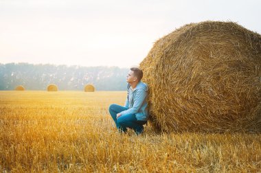 Genç adam saman balya yakınındaki