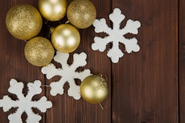 Bolas de Navidad de oro y decoración de copos de nieve sobre fondo de madera —  Fotos de Stock