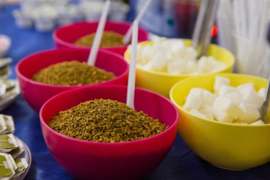 Pembe plaka ve sarı bir tabak içinde rafine şeker çözünür kahve