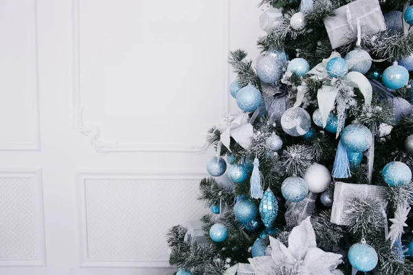 Blauwe en witte kerstversiering op de nieuwjaarsboom in het interieur — Stockfoto