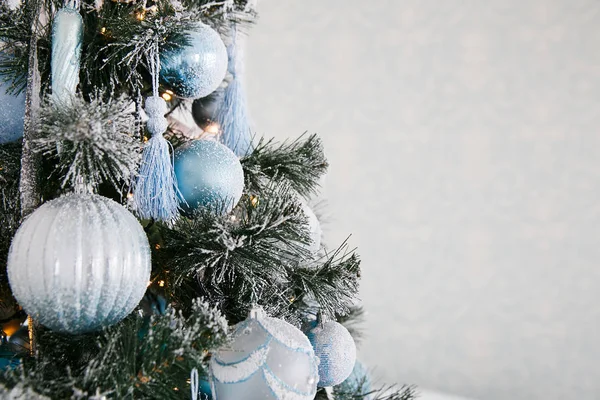 파란색 과 하얀색으로 된 크리스마스 장식들 이 집 안에 있는 새해 트리에 있습니다. — 스톡 사진