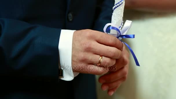 Novia y novio sostienen gruesas velas blancas en sus manos durante la ceremonia — Vídeos de Stock