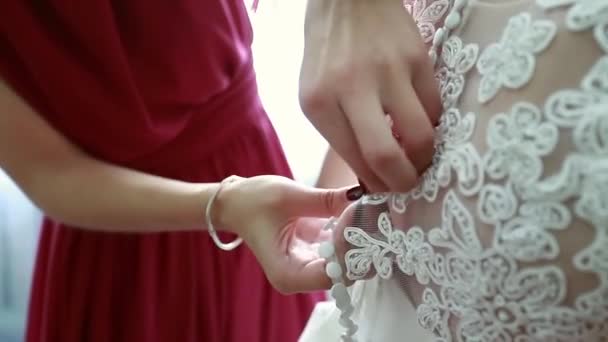 Damigella fa bow-nodo sul retro del vestito da sposa spose — Video Stock