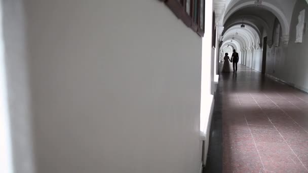 Sposa sta davanti sposo in corridoio bianco all'interno — Video Stock