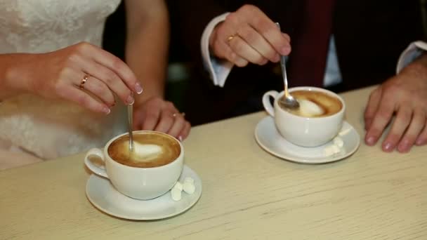 Hände von Braut und Bräutigam mit einer Tasse Kaffee — Stockvideo
