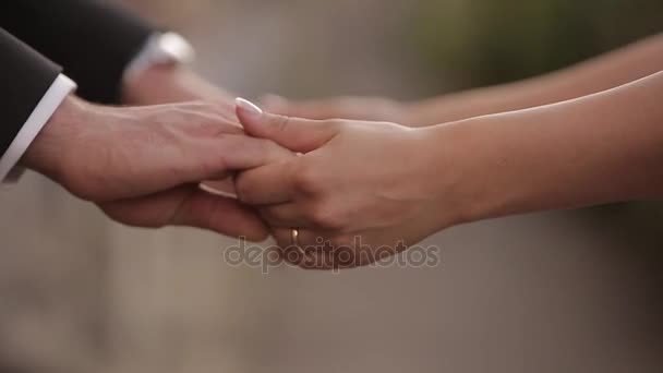 Em um noivo de dia de casamento põe uma aliança de casamento no dedo de uma noiva. A noiva põe um anel no dedo de um noivo — Vídeo de Stock