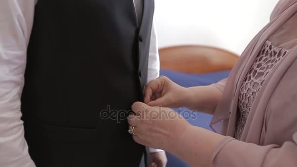 Moeder helpt zip van de bruidegom vest — Stockvideo