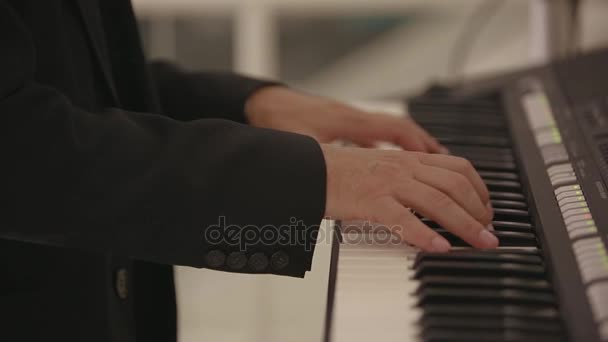 Ένας άντρας παίζει ένα ηλεκτρονικό πιάνο σε ένα γάμο — Αρχείο Βίντεο
