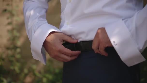 Hochzeit, der Bräutigam kleidet sich in einem grünen Garten — Stockvideo