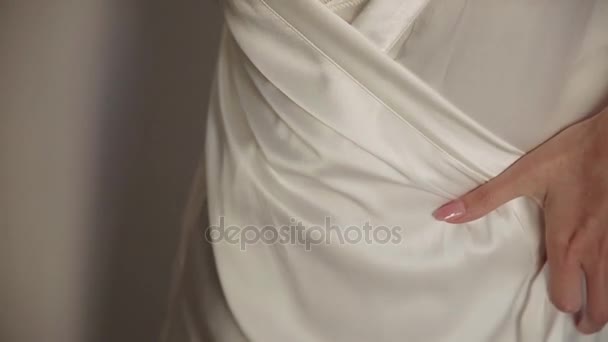 Matrimonio, la sposa allaccia la cintura di un cappotto bianco — Video Stock