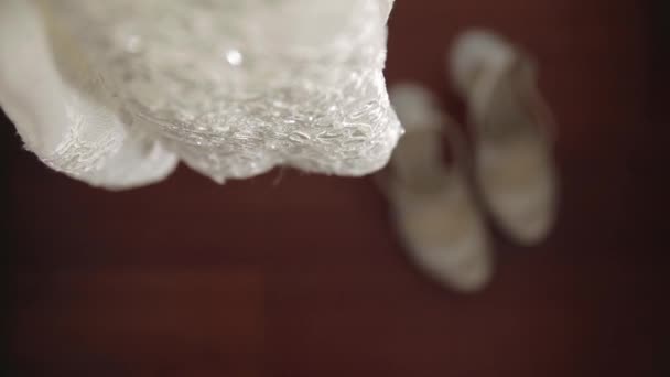 La novia lleva zapatos de boda blancos con sus manos — Vídeo de stock