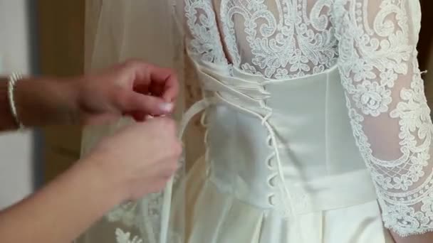 Hjälper snöra på brudens klänning — Stockvideo
