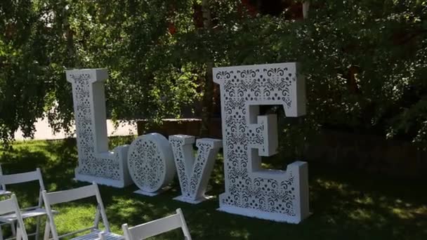Decoración para la ceremonia de la boda, una enorme inscripción Amor — Vídeos de Stock