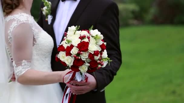 El día de la boda el novio acaricia la mano de las novias, el ramo de bodas — Vídeos de Stock