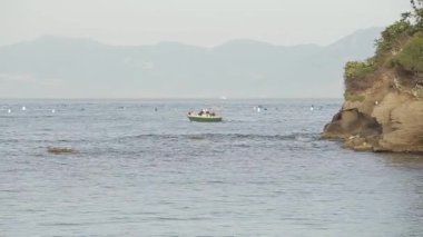 küçük bir tekne bir ada Dağları ile arka plan üzerinde deniz boyunca yelken