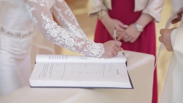 Wedding ceremony in the church, the bride and groom sign — Stock Video