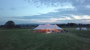 Aerial view. Wedding reception ceremony setup with big white tents and people enjoying USA