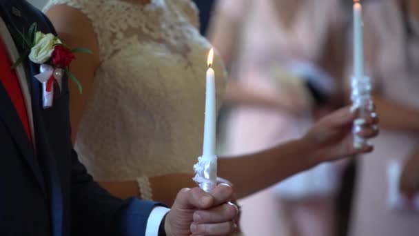 Boda, cierre, novia y novia con velas en la iglesia — Vídeos de Stock